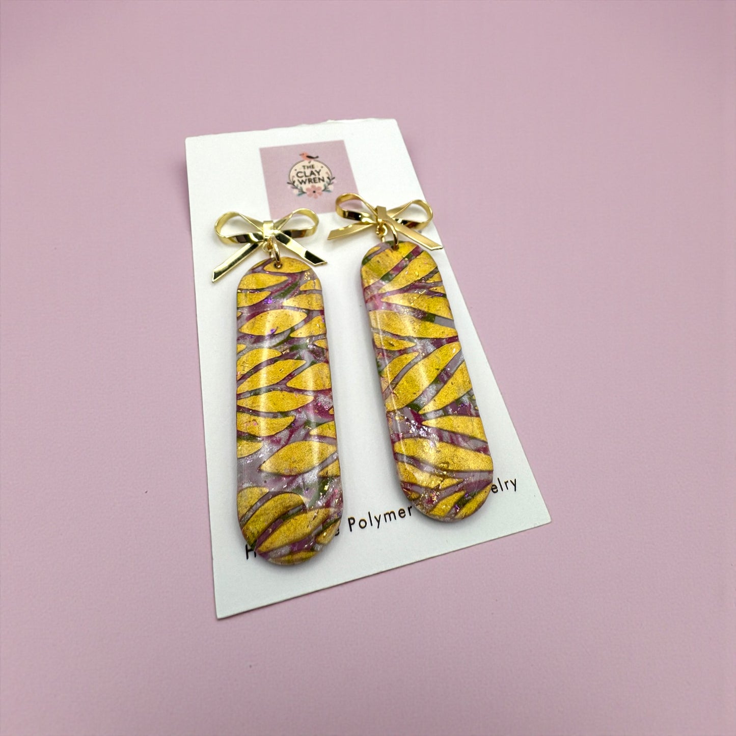 Pinkmas long oval dangles with gold bow stud