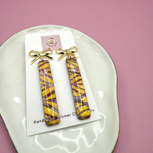 Pinkmas narrow rectangle dangles with gold bow stud