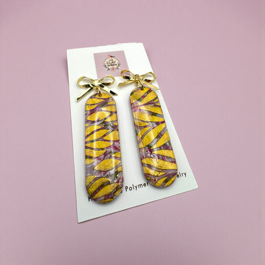 Pinkmas long oval dangles with gold bow stud